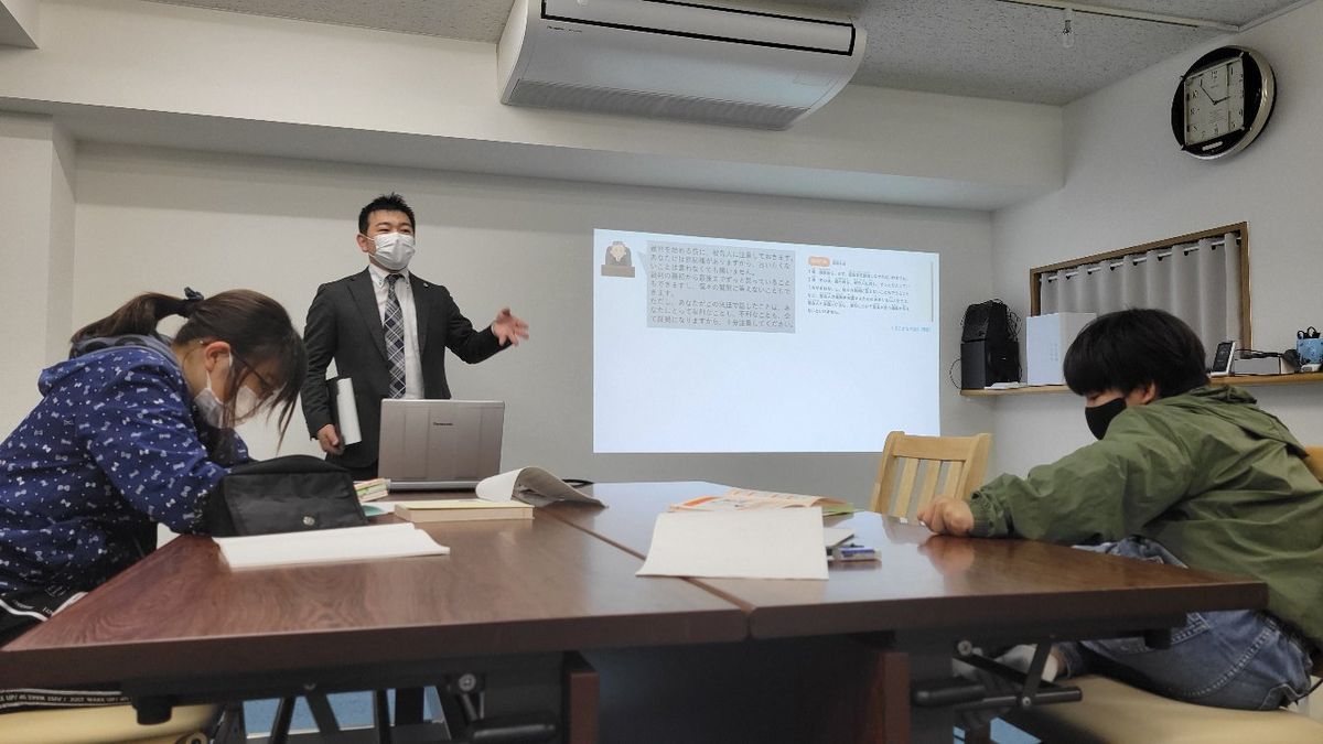 スクリーンに資料を映しながら進める授業の様子。オンラインでも同じ内容を受講できる